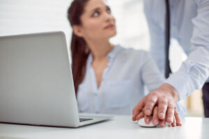 Nice pleasant young woman sitting at the table and working while feeling a male hand on hers