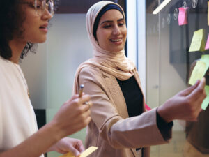 Women using adhesive notes in office