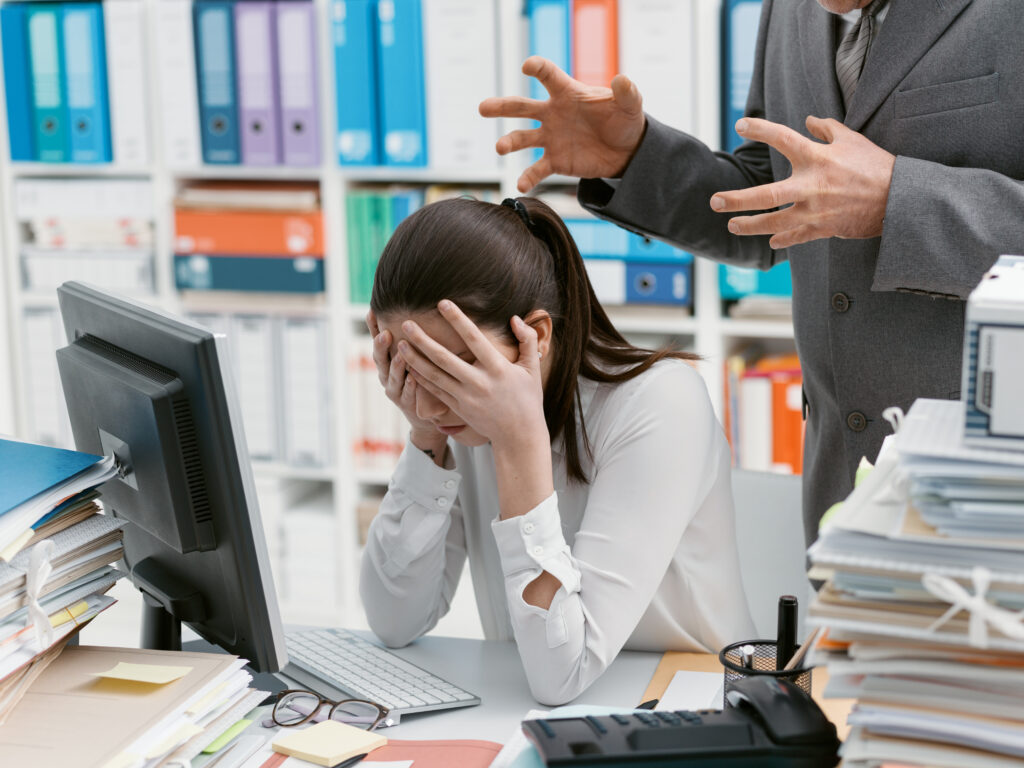 Angry boss yelling at his young employee